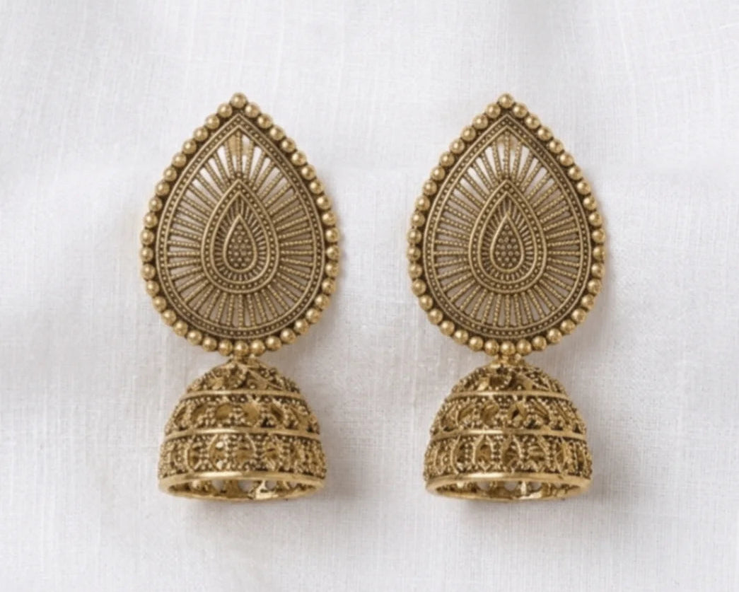 Pair of gold earrings on a white fabric background