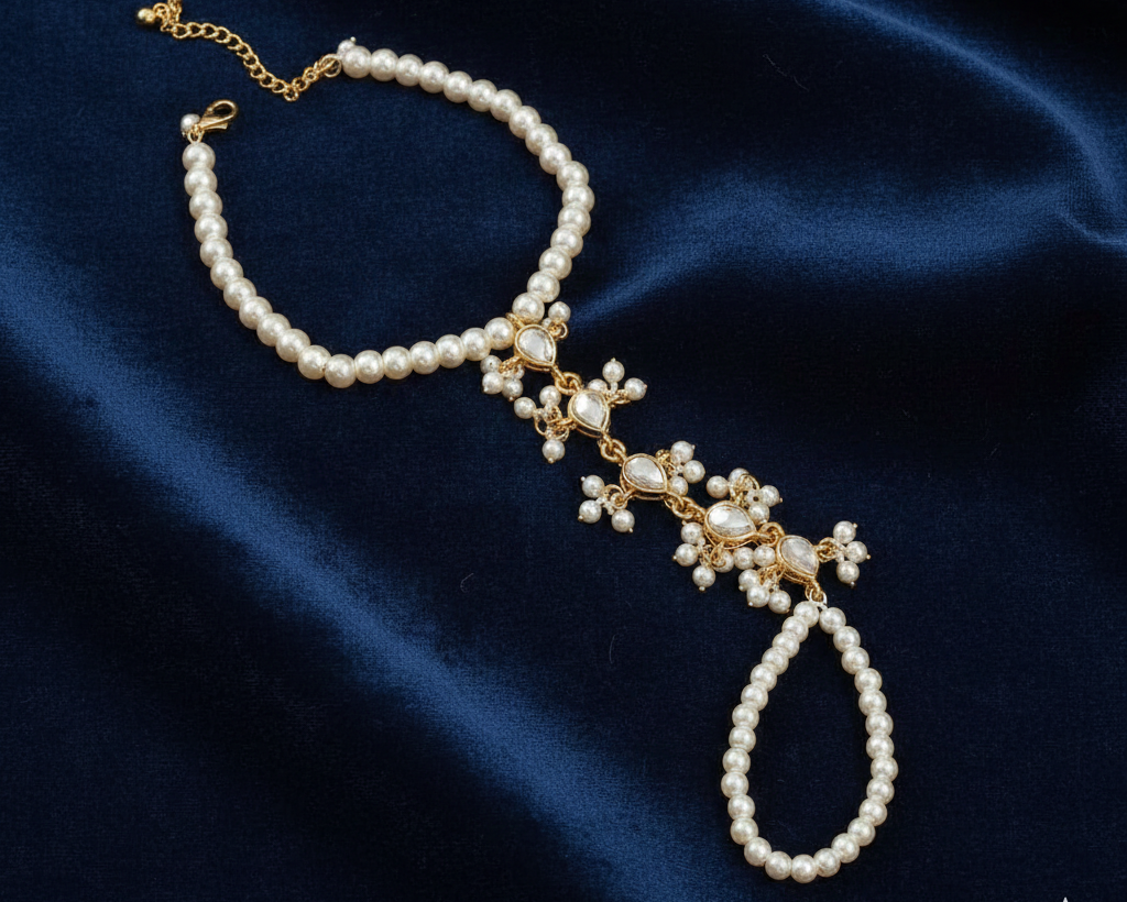 Pearl and gold bracelet on a dark blue fabric background