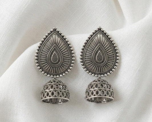 Pair of silver earrings on a white fabric background