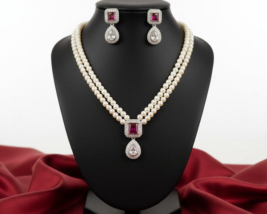 Pearl necklace and earrings set on a black stand with red fabric background