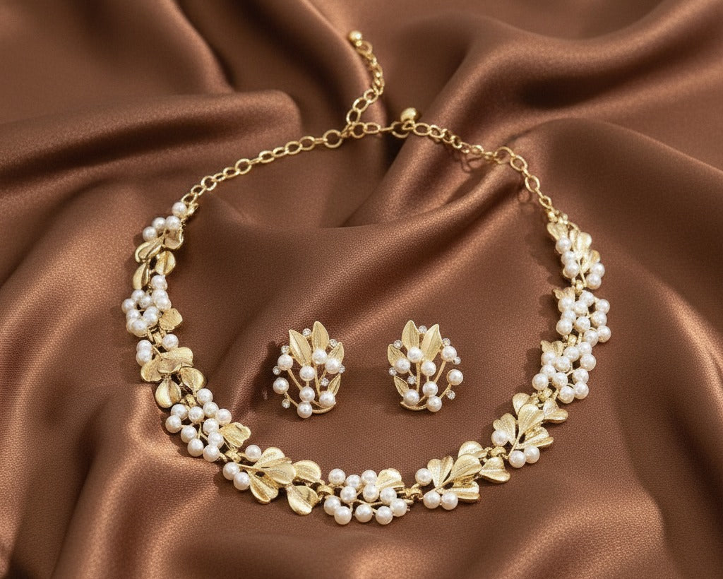 Gold necklace and earrings set on brown satin fabric