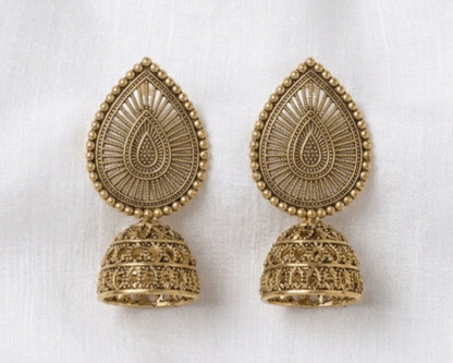 Pair of gold earrings on a white fabric background