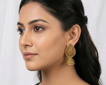 Woman wearing gold earrings against a white background