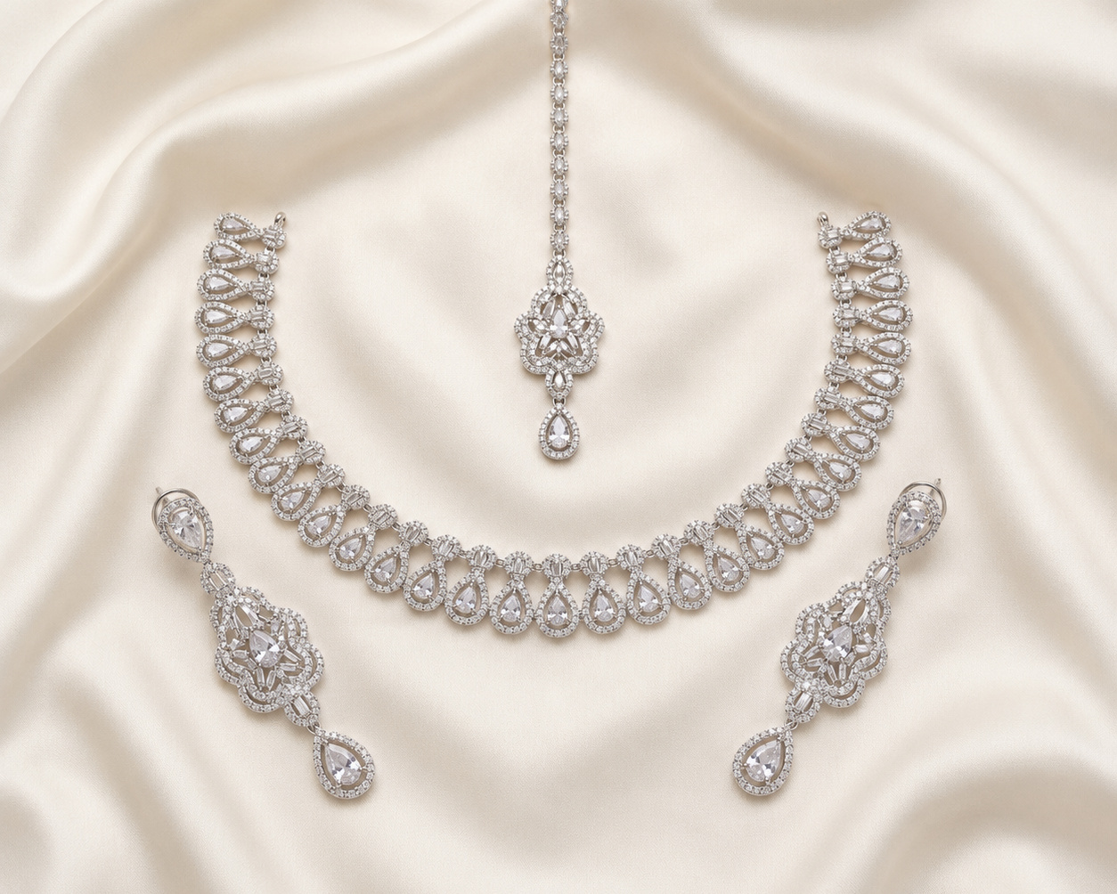 Silver necklace and earrings set on a satin background