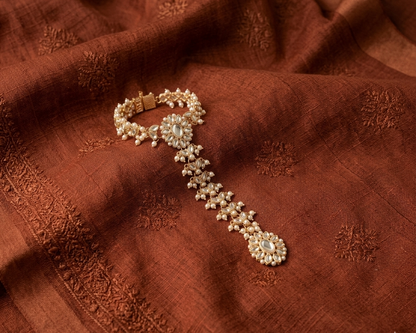 Pearl bracelet on a textured brown fabric background