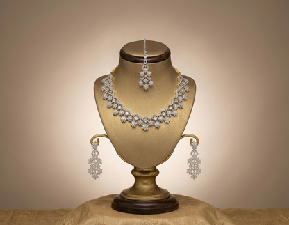 Diamond necklace and earrings on a gold bust with a beige background