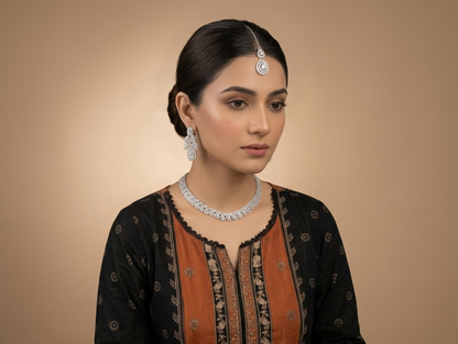Woman wearing traditional attire with jewelry against a beige background