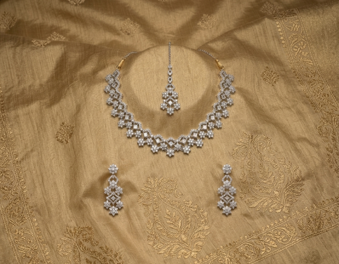 Silver jewelry set on a gold fabric background