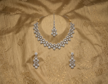 Silver jewelry set on a gold fabric background