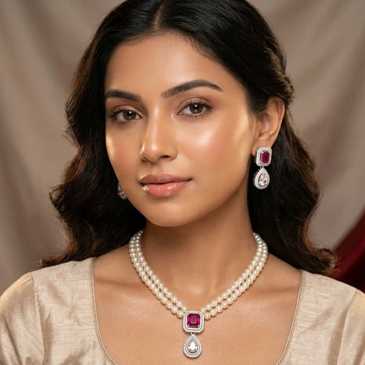 A woman wearing a matching pearl necklace and drop earrings with square pink gemstones and silver settings, shown in a close-up portrait against a draped beige background.