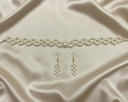 Pearl necklace and earrings on a satin surface