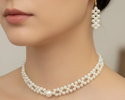 Pearl necklace and earrings on a model against a neutral background