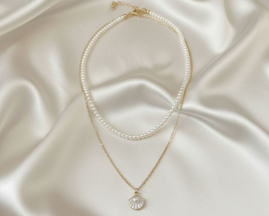 Two pearl necklaces on a satin surface