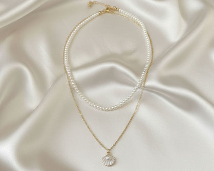 Two pearl necklaces on a satin surface