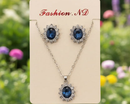 Jewelry set with blue gemstones on a 'Fashion ND' card against a blurred floral background