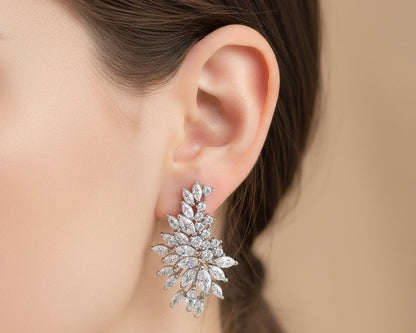 Close-up of a woman's ear wearing a sparkling diamond earring against a neutral background