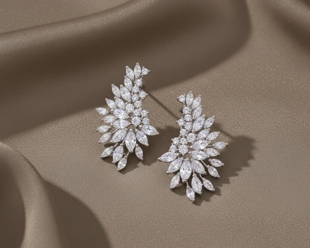 Pair of diamond earrings on a beige fabric background