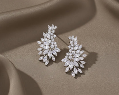 Pair of diamond earrings on a beige fabric background