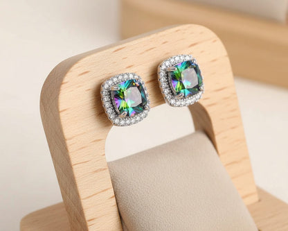Multicolored gemstone earrings on a wooden stand with a neutral background