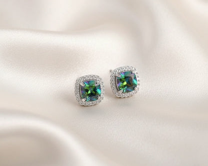 Pair of earrings with colorful gemstones on a satin surface