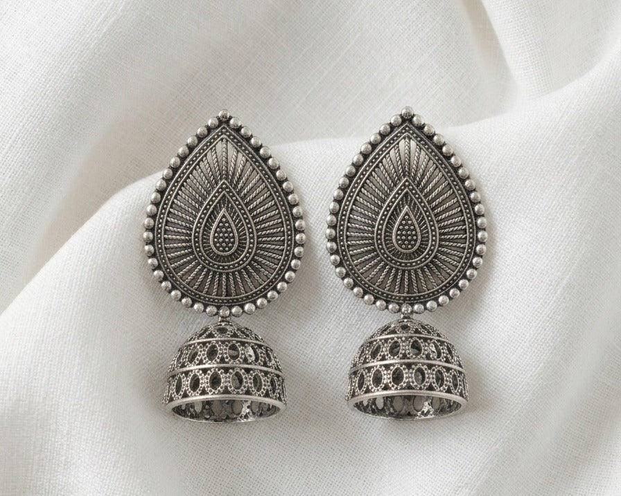 Pair of silver earrings on a white fabric background