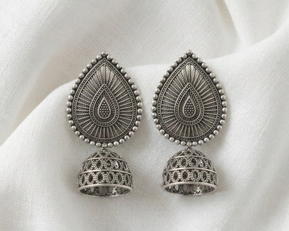 Pair of silver earrings on a white fabric background