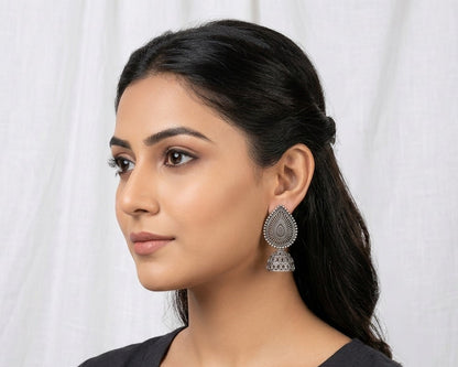 Woman wearing silver earrings against a white background
