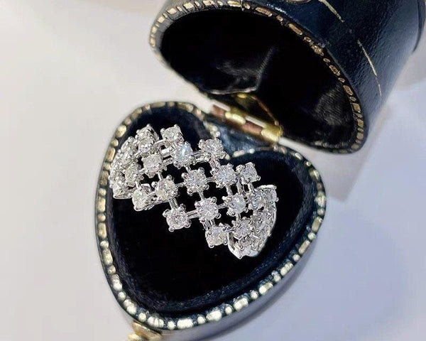 Silver diamond earring in a heart-shaped jewelry box on a white background