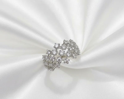 Silver ring with gemstones on a white satin background