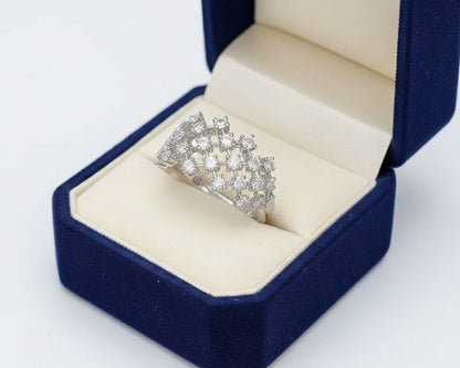 Silver ring with gemstones in a blue jewelry box on a white background
