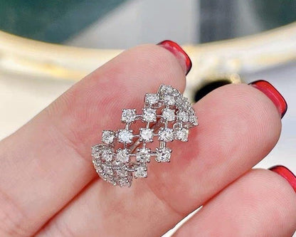 Diamond earring held between fingers with a blurred background