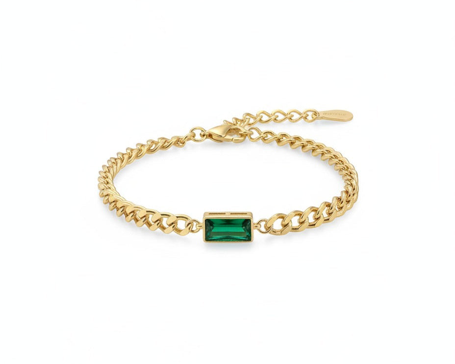 Gold bracelet with a green gemstone on a white background