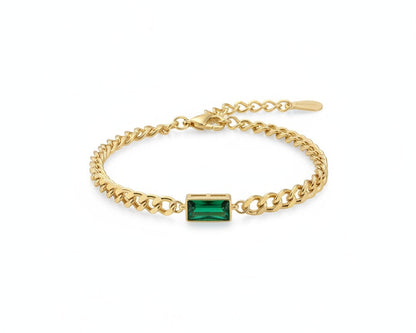 Gold bracelet with a green gemstone on a white background