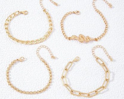 Four gold bracelets on a white background
