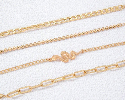Three gold chains on a textured white background