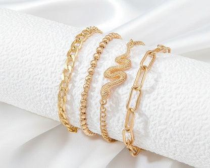 Three gold bracelets on a white textured surface