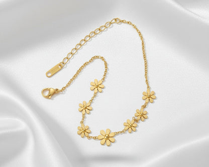 Gold floral bracelet on a white satin background