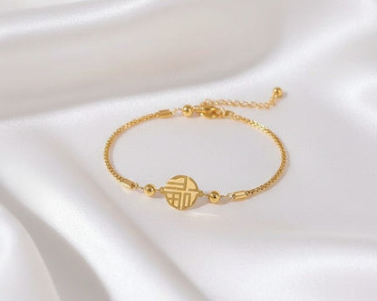 Gold bracelet on a white satin background