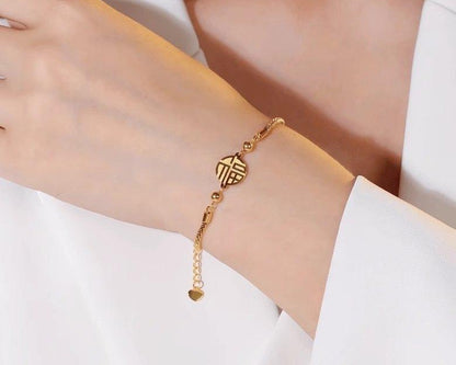 Gold bracelet on a person's wrist with a plain background
