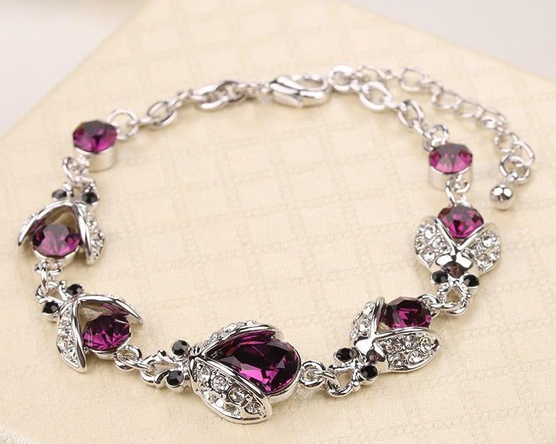 Silver bracelet with purple gemstones on a light background