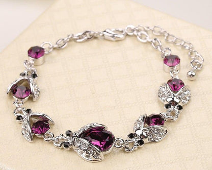 Silver bracelet with purple gemstones on a light background