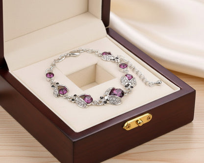 Silver bracelet with purple gemstones in a wooden jewelry box