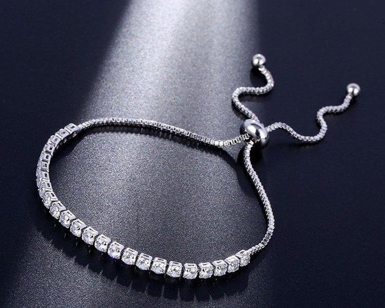Silver bracelet with clear stones on a dark background