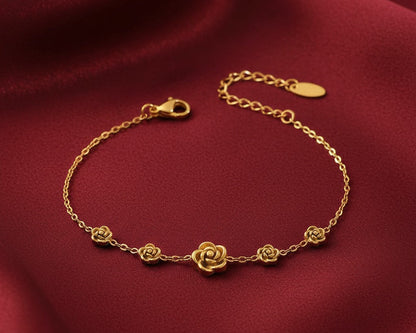 Gold bracelet with floral designs on a red fabric background