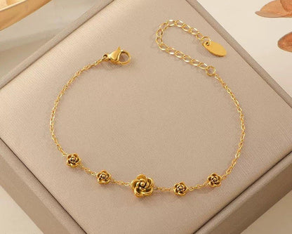 Gold bracelet with floral designs on a beige jewelry box
