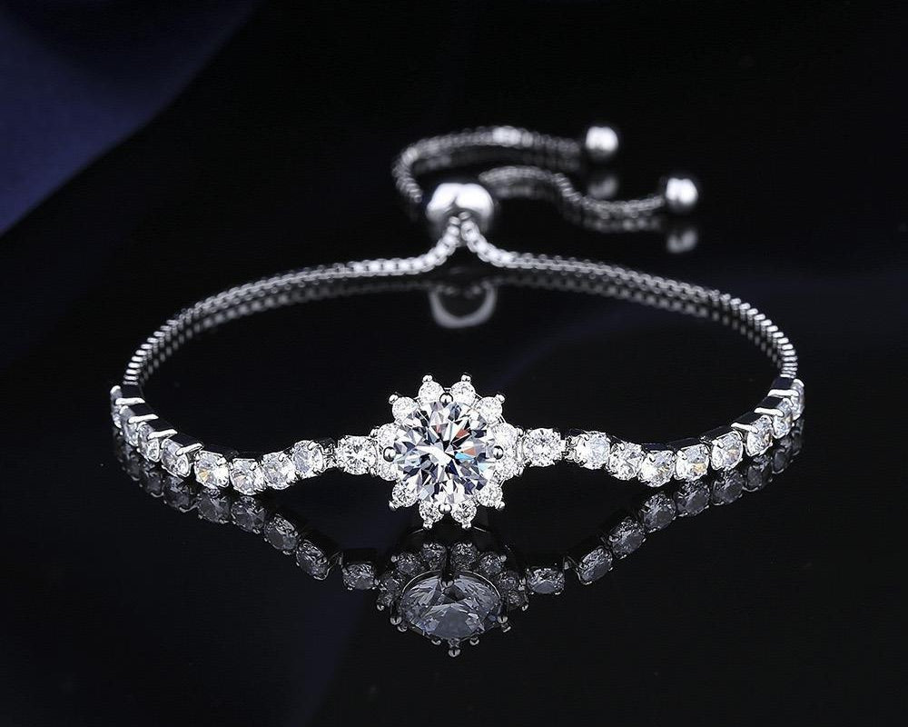 Silver bracelet with a central diamond on a dark background