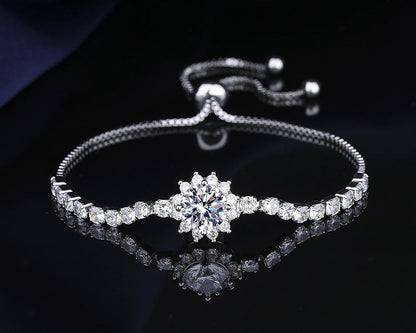 Silver bracelet with a central diamond on a dark background