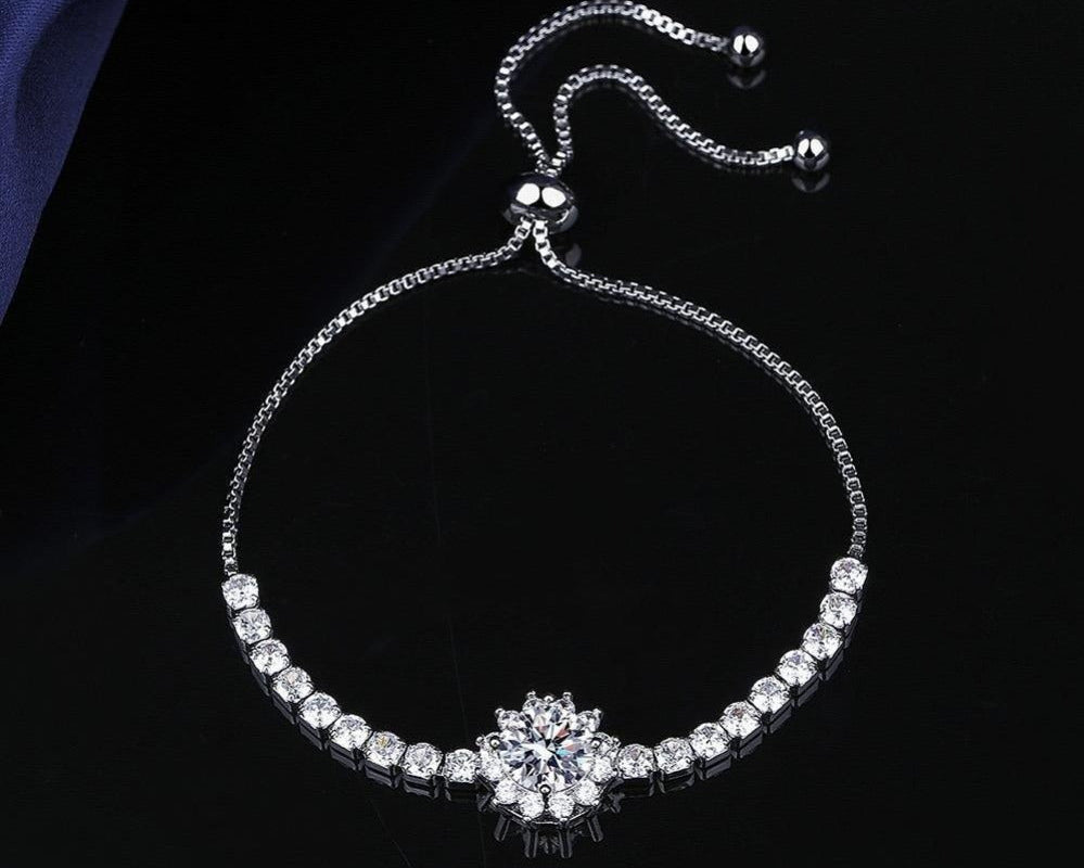 Silver bracelet with a floral clasp on a dark background