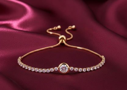 Gold bracelet with a central diamond on a burgundy fabric background