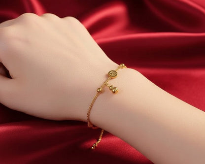 Gold bracelet on a wrist against a red satin background